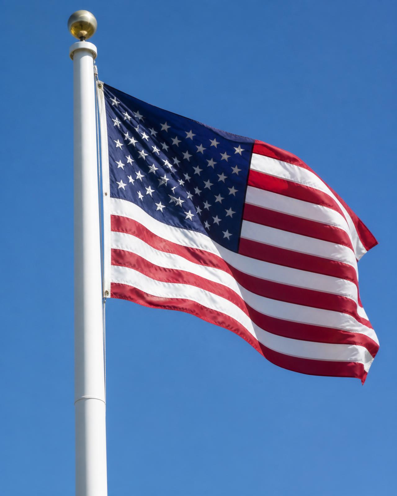 American flag flying on a white fiberglass flagpole